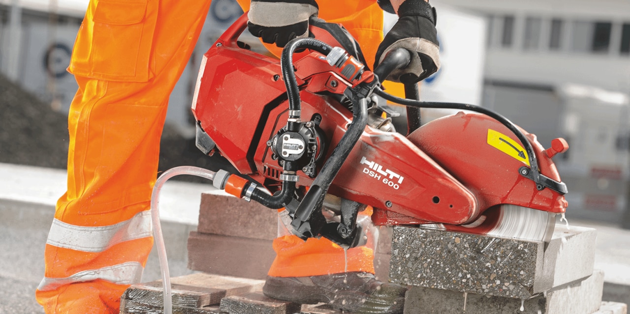 Construction worker cutting concrete using a DSH 600-X Gas saw which comes with a quick-acting brake